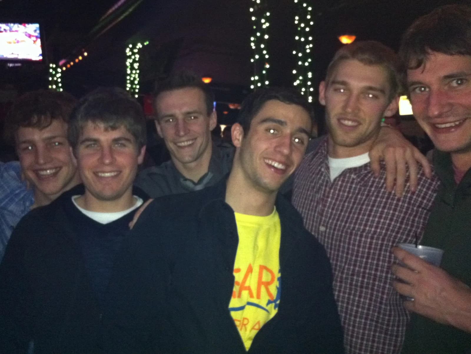 Sam, Bryan, Gabe, Stump, Ben, and Metro at a bar with string lights