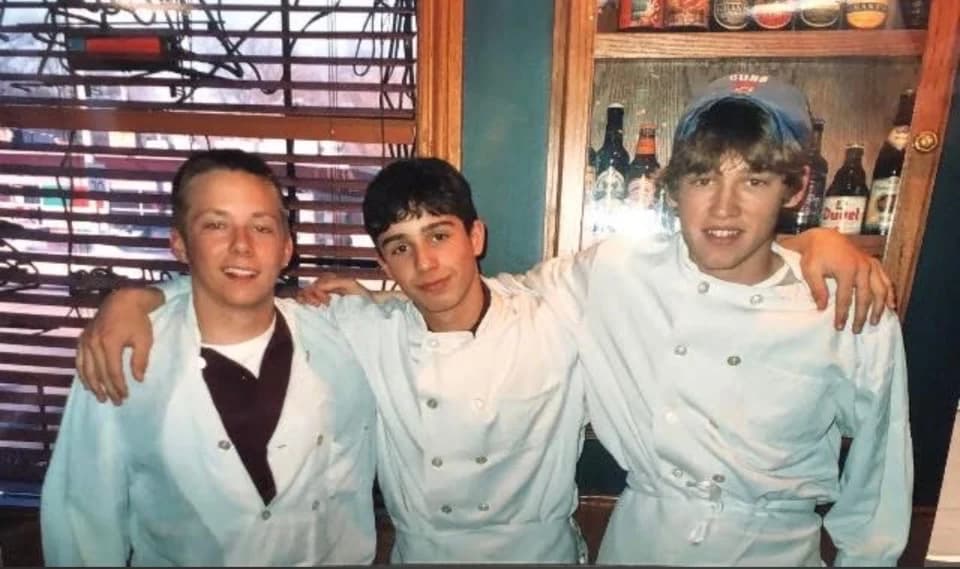 Jimmy Peters, Metro, and Sam in white serving jackets behind a restaurant bar