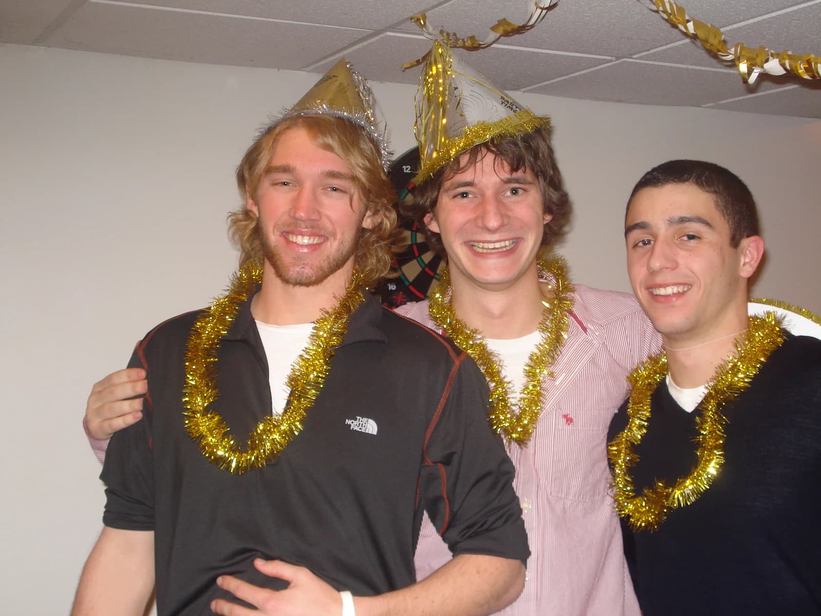 Sam, Bryan, and Metro with party hats and gold tinsel on New Year's Eve