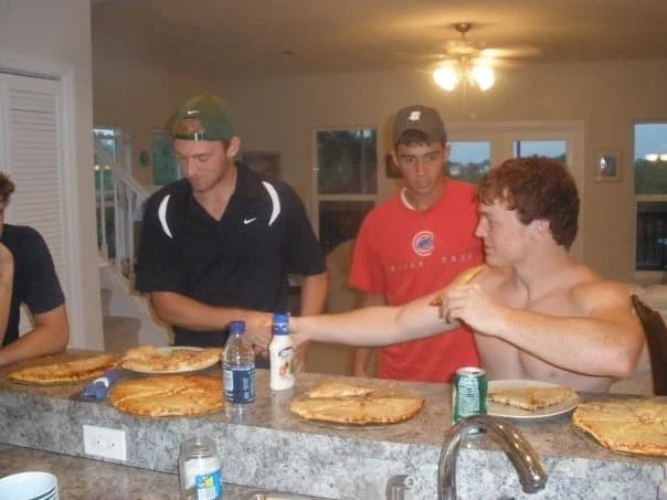 Sam, Metro, and Gabe in a kitchen with pizzas on the counter