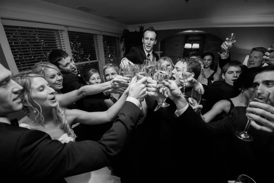 Sam, Kellirose, and the whole crew raising glasses at the Sweeney wedding reception